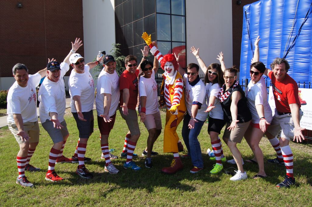 Ronald McDonald House Charities Oklahoma City Board of Directors posing with Ronald McDonald wearing red & white striped socks