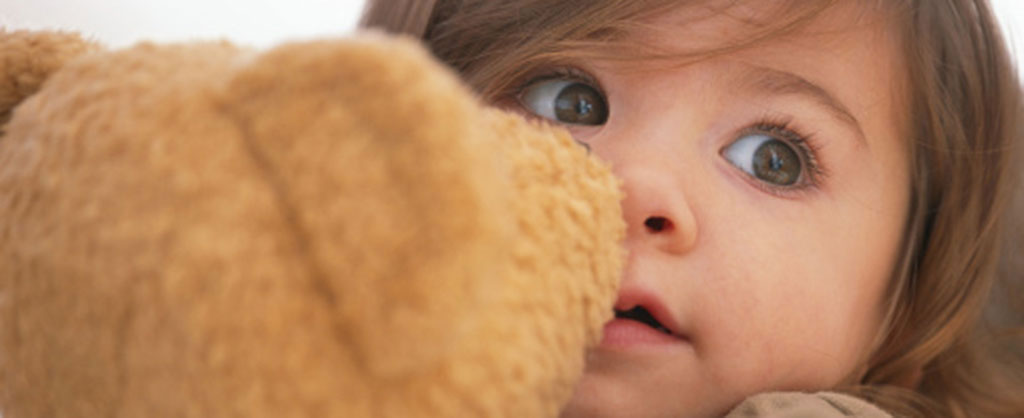 A little girl holding her teddy bear