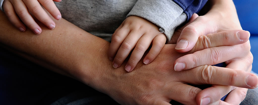 A baby's hand grabbing an adult hand