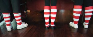 Three pair legs wearing red & white striped socks