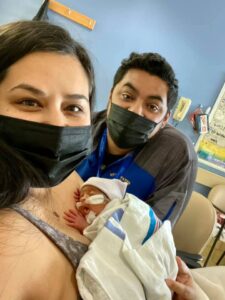 Mother and father posing with premature son.